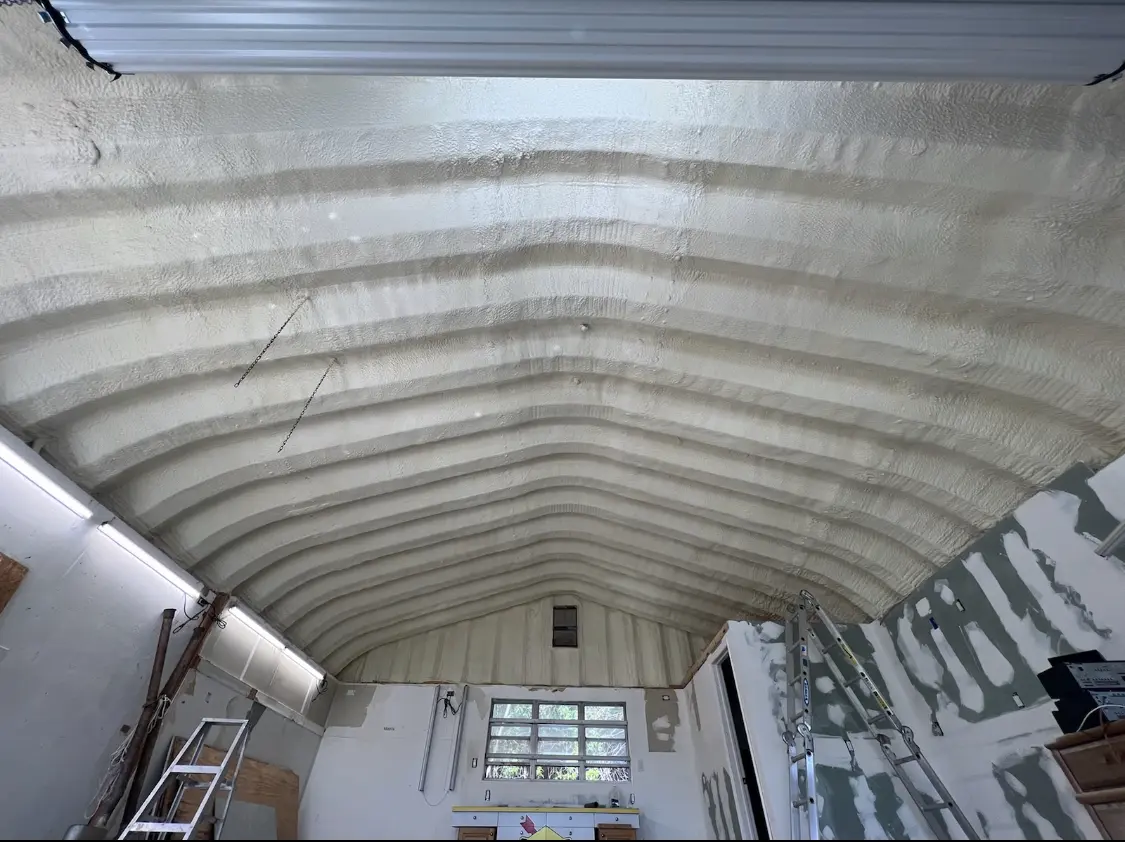 Spray polyurethane foam applied to the underside of a metal roof deck in Grove